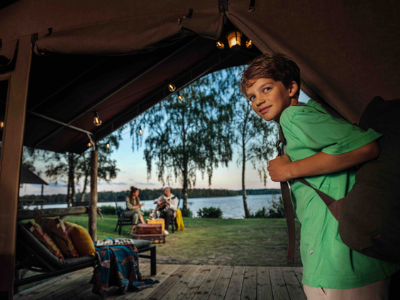 Jongen geniet van het uitzicht over het water vanuit een luxe safaritent op Lake Resort Beekse Bergen