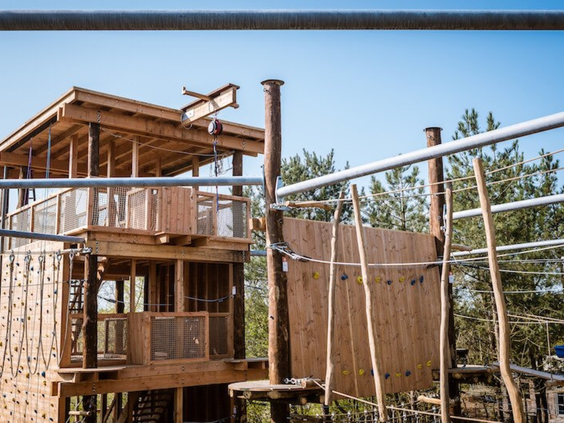Groot avontuurlijk houten speeltoestel met een klimtoren voor kinderen op Vakantiepark Boomhiemke.