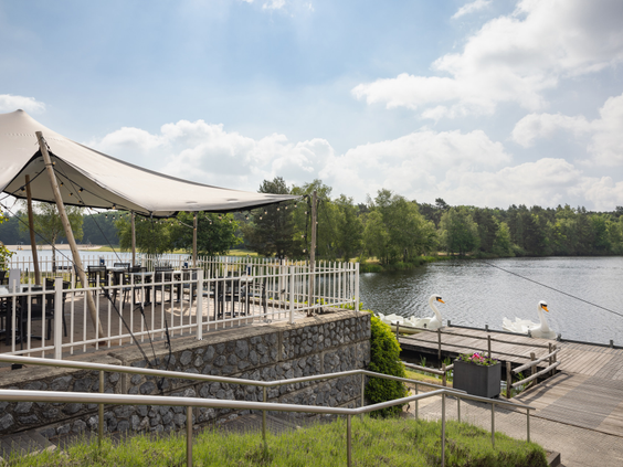 Het sfeervolle terras van het restaurant op Vakantiepark Bospark 't Wolfsven, gelegen direct aan het recreatiemeer.