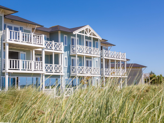 Het blauwe appartementencomplex in de duinen op Vakantiepark Cape Helius, met ruime balkons.