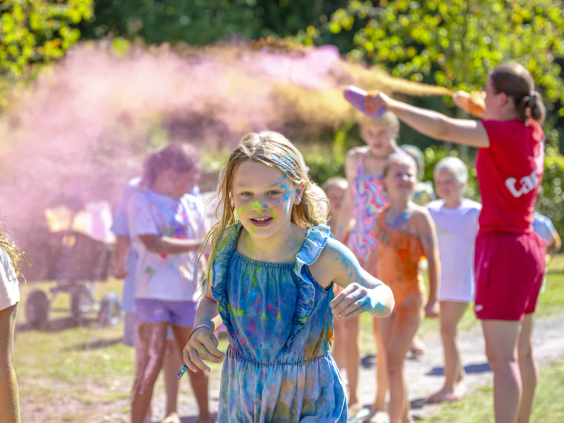 Kinderen onder het vrolijke kleurenpoeder tijdens een color run op de camping