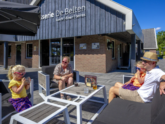 Het zonnige buitenterras van de brasserie op het vakantiepark in Overijssel
