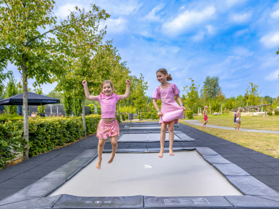 Meerdere kinderen springen tegelijkertijd hoog in de lucht op de airtrampoline