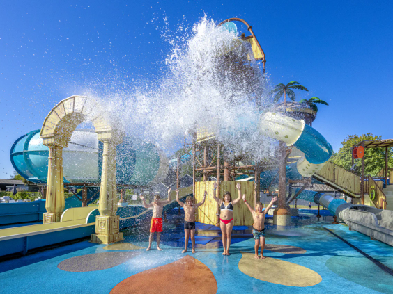 Een enorme emmer water kiept om over spelende kinderen in het waterpark