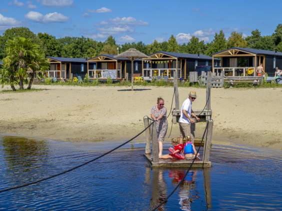 Kinderen op een houten trekvlot over de speelvijver bij de Belten