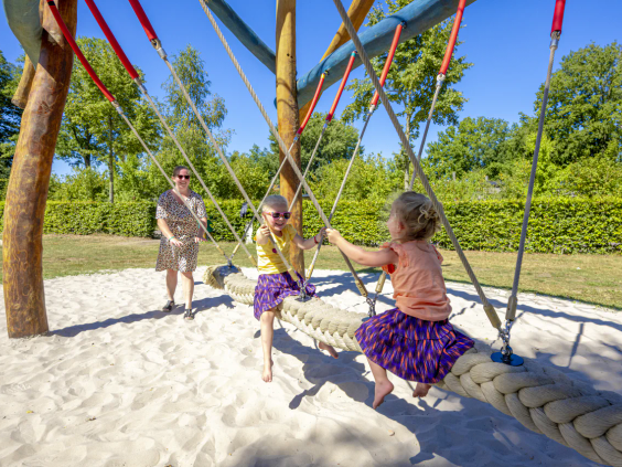 Kinderen spelen samen op een schommel in de speeltuin