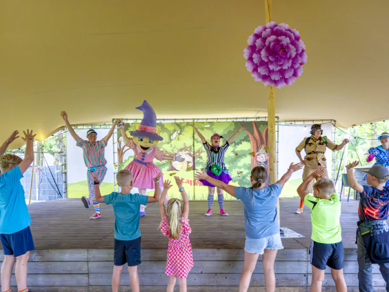 Kinderen dansen met de vrolijke mascotte Carabouille in de animatiezaal