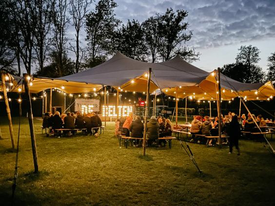 Het sfeervol verlichte terras van het restaurant tijdens een warme zomeravond