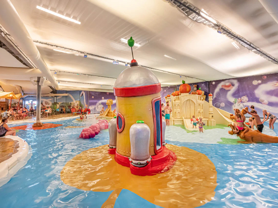 Een kind speelt bij de waterfonteinen in de overdekte Holle Bolle Plons