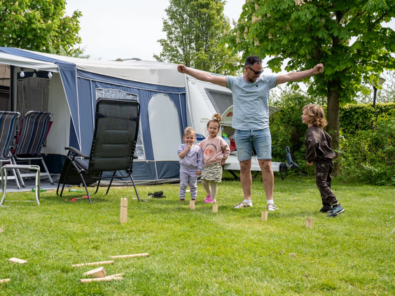 Een gezin voor hun tent op een ruime kampeerplaats op de Bongerd