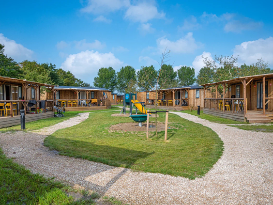 Moderne vakantiehuisjes en lodges gelegen aan een groen gazon op de Bongerd