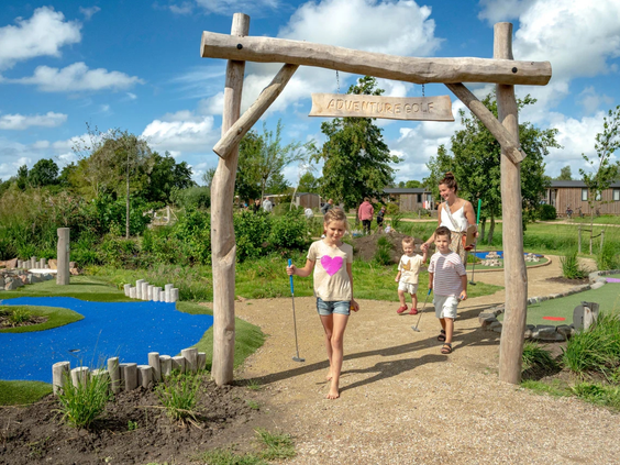 Familie speelt een potje minigolf op de baan van de camping
