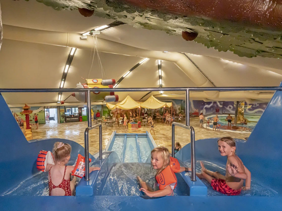 Kinderen spelen met zwembanden in het grote buitenzwembad