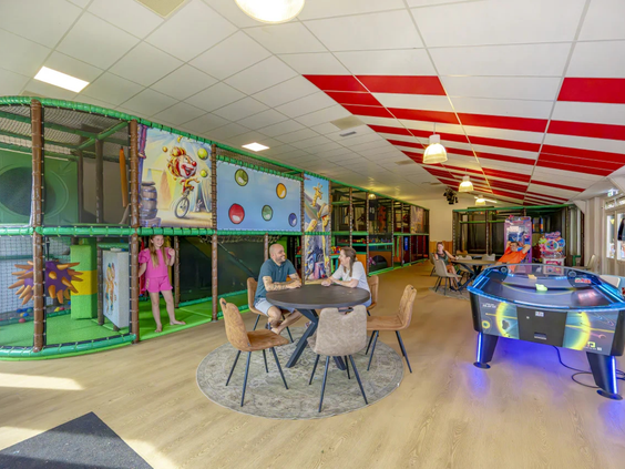 De game room met airhockey en arcade spellen op de camping