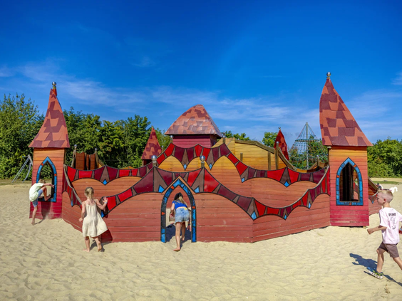 Groot rood speelkasteel in de buitenspeeltuin voor kinderen