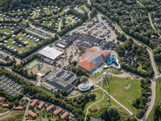 Een luchtfoto toont de grootte en de vele faciliteiten van Vakantiepark De Krim op Texel, inclusief zwembad, camping en huisjes.