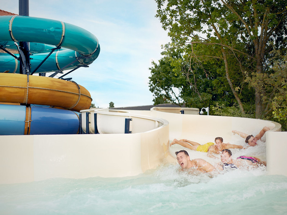 Kinderen glijden met veel plezier van de brede familieglijbaan in het zwemparadijs van Vakantiepark De Krim.
