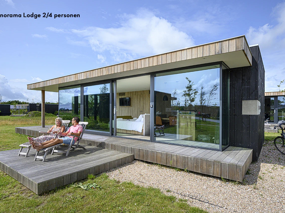 De buitenkant van een moderne vakantielodge met houten terras op de Pekelinge
