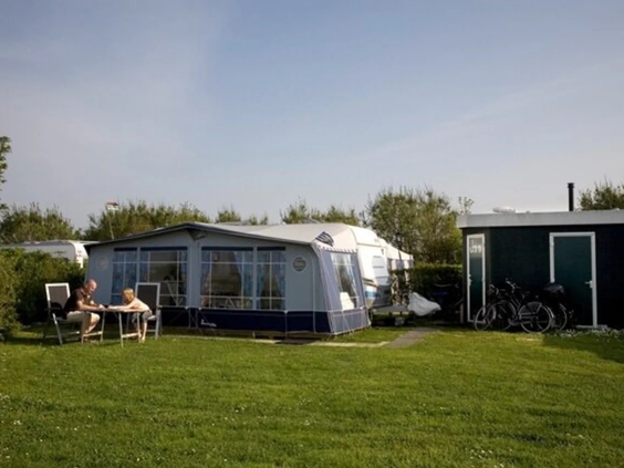 Een ruime en groene kampeerplaats voor caravans op de camping in Oostkapelle