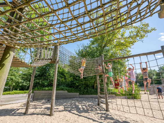 Groot houten speeltoestel met uitdagende klimnetten voor de kinderen