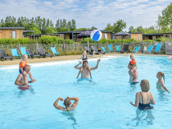 Mensen en kinderen hebben plezier in het water van het grote buitenzwembad