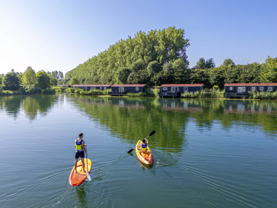 Mensen in kano's varen over het grote recreatiemeer van de camping