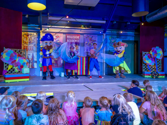 Het animatieteam en mascotte Carabouille geven een show op het podium voor kinderen