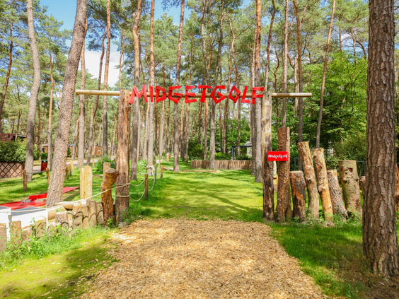 De houten entree van de midgetgolfbaan gelegen in de bossen van het park