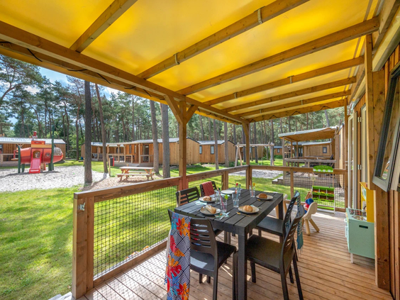 Het overdekte houten terras van een luxe vakantielodge