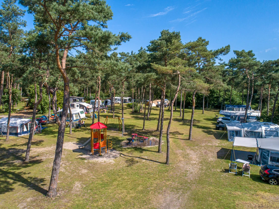 Luchtfoto van de kampeervelden en accommodaties tussen de bossen op de Scheepsbel