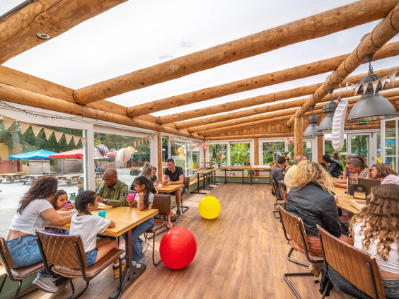 Een familie geniet samen van een maaltijd in het restaurant op het park