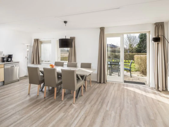 De lichte woonkamer en eethoek in een modern vakantiehuis op Vakantiepark De Soeten Haert.