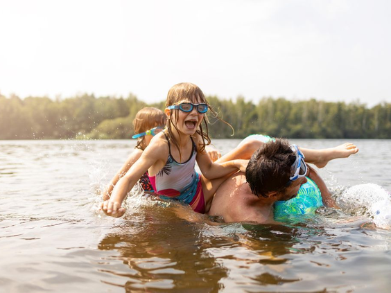 Kinderen spelen en zwemmen vol plezier in het natuurlijke zwemwater van de recreatieplas op Vakantiepark De Strabrechtse Vennen.