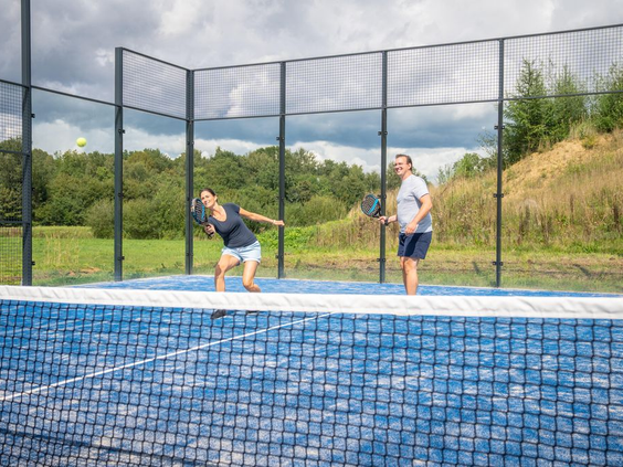 Twee mensen spelen een potje padel op de outdoor padelbaan van Vakantiepark De Strabrechtse Vennen.
