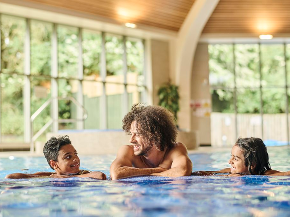 Een gezin met kinderen geniet en ontspant in het overdekte binnenzwembad van Vakantiepark De Strabrechtse Vennen.