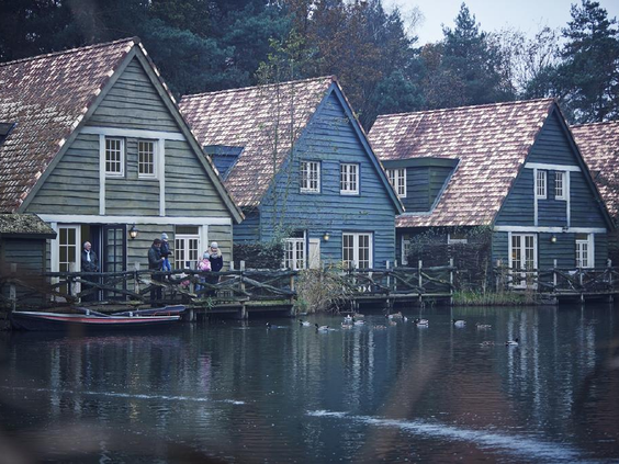 Sfeervolle houten Boshuysen aan het water in Vakantiepark Efteling Bosrijk, omgeven door natuur.