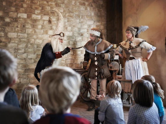 Klaas Vaak en een Zandkabouter vertellen een verhaaltje voor het slapengaan aan de kinderen in Efteling Bosrijk.