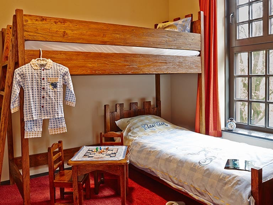 Kinderslaapkamer in een vakantiehuis van Efteling Bosrijk, met een houten stapelbed en een slaapmutsje van Klaas Vaak.