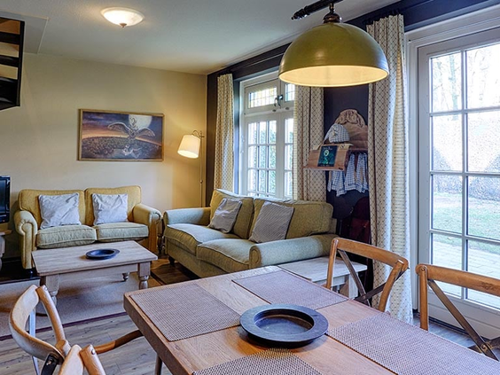 De gezellige woonkamer en eethoek van een Dorpshuys of Boshuys in Vakantiepark Efteling Bosrijk.