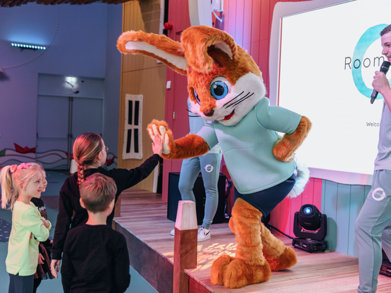 Kinderen geven parkmascotte Koos Konijn een high five tijdens een levendige meeleeftheatershow op het podium van Vakantiepark Egmond aan Zee.