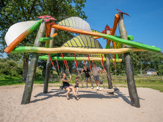 Een modern houten en touwen schommel in de buitenlucht
