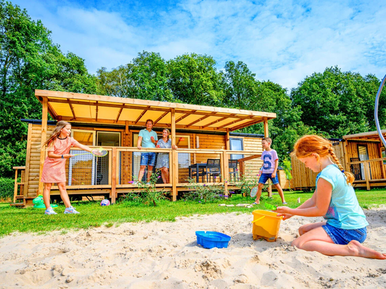 Jonge kinderen spelen in een zandbak bij de accommodaties