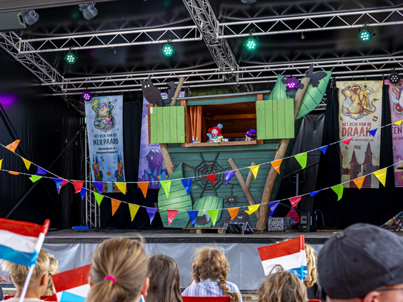 Kinderen kijken naar een poppenkastvoorstelling op de camping