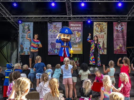 Het animatieteam geeft een show op het podium met mascottes voor de kinderen