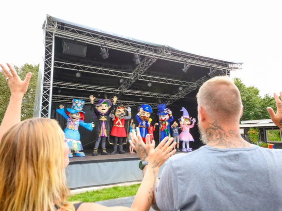 Publiek kijkt naar een show op het buitenpodium van de camping