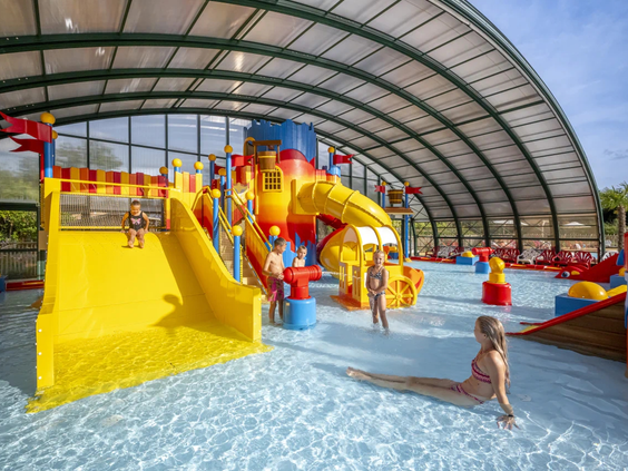 Overdekt peuterbad met waterspeeltuin en kleine glijbanen voor jonge kinderen
