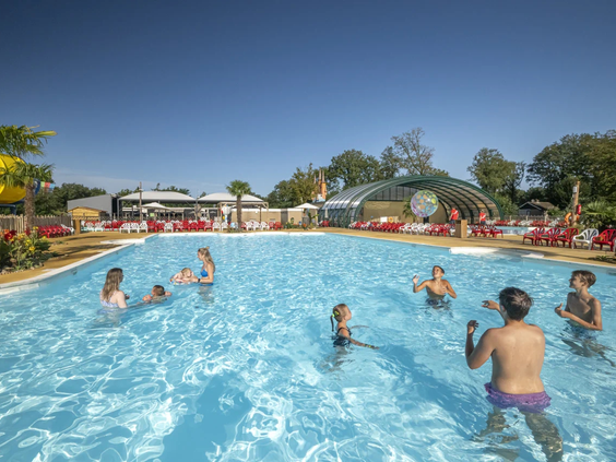 Mensen zwemmen en spelen in het grote buitenzwembad op een zonnige dag
