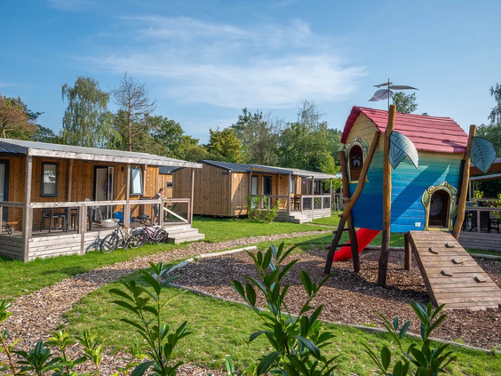 Moderne stacaravans met een houten speeltoestel voor de deur