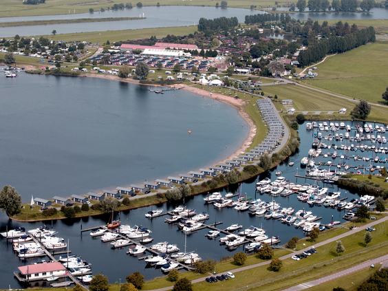 Luchtfoto van Vakantiepark Eiland van Maurik, gelegen aan een grote recreatieplas in Gelderland met een eigen zandstrand en jachthaven.