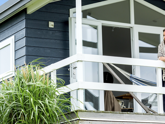 Detail van de veranda van een moderne, donkerblauwe vakantiechalet op Vakantiepark Eiland van Maurik.